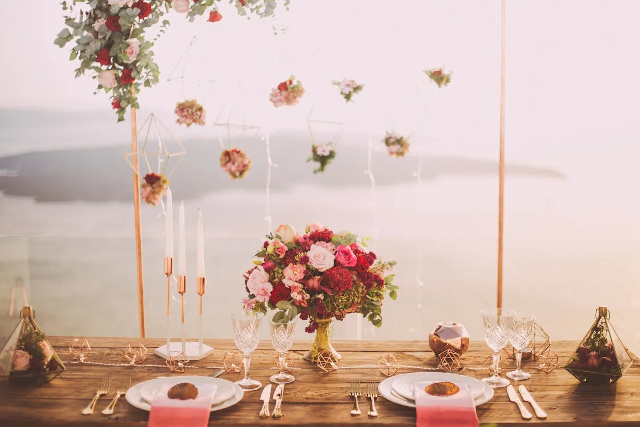 Pink and red roses as a centrepiece with silverware on a table