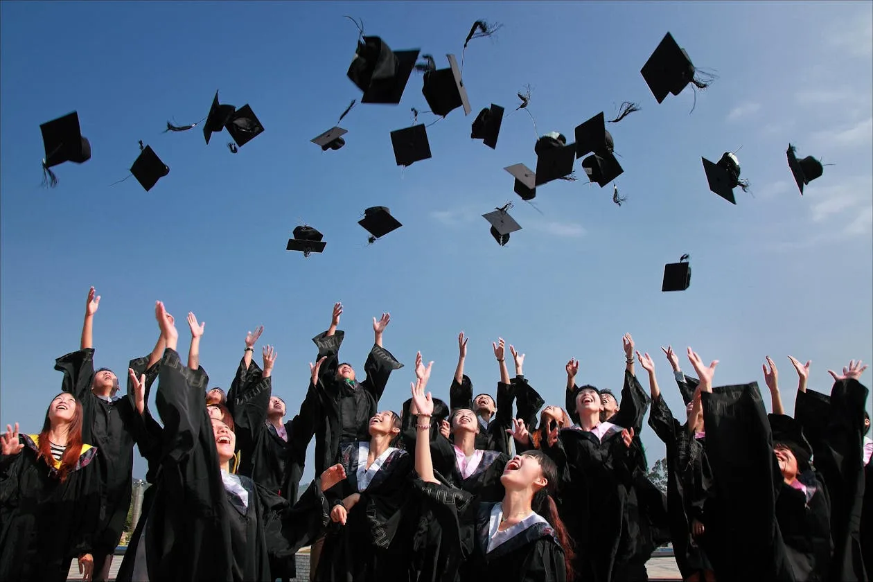 Graduation cap and diploma on a wooden surface
