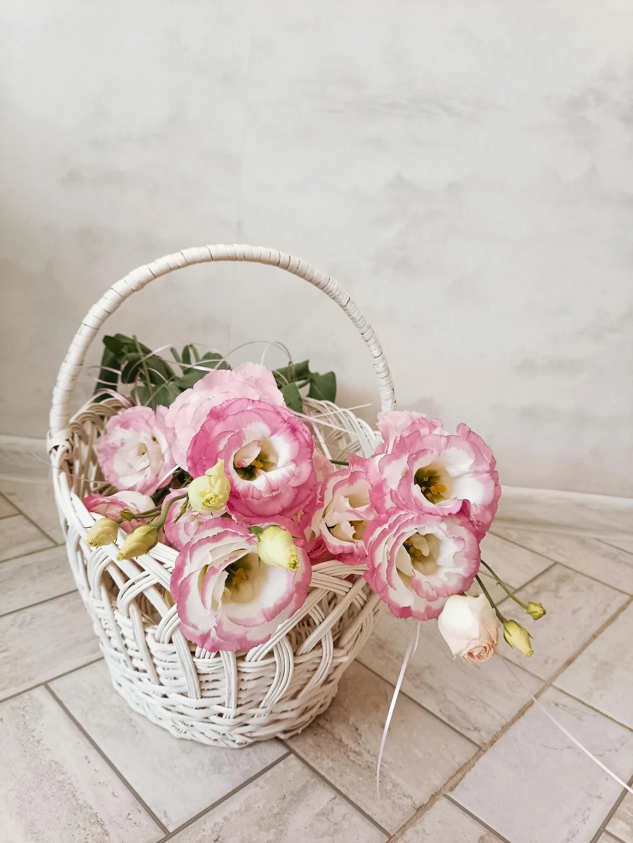 Elegant pink lisianthus flowers arranged in a woven basket