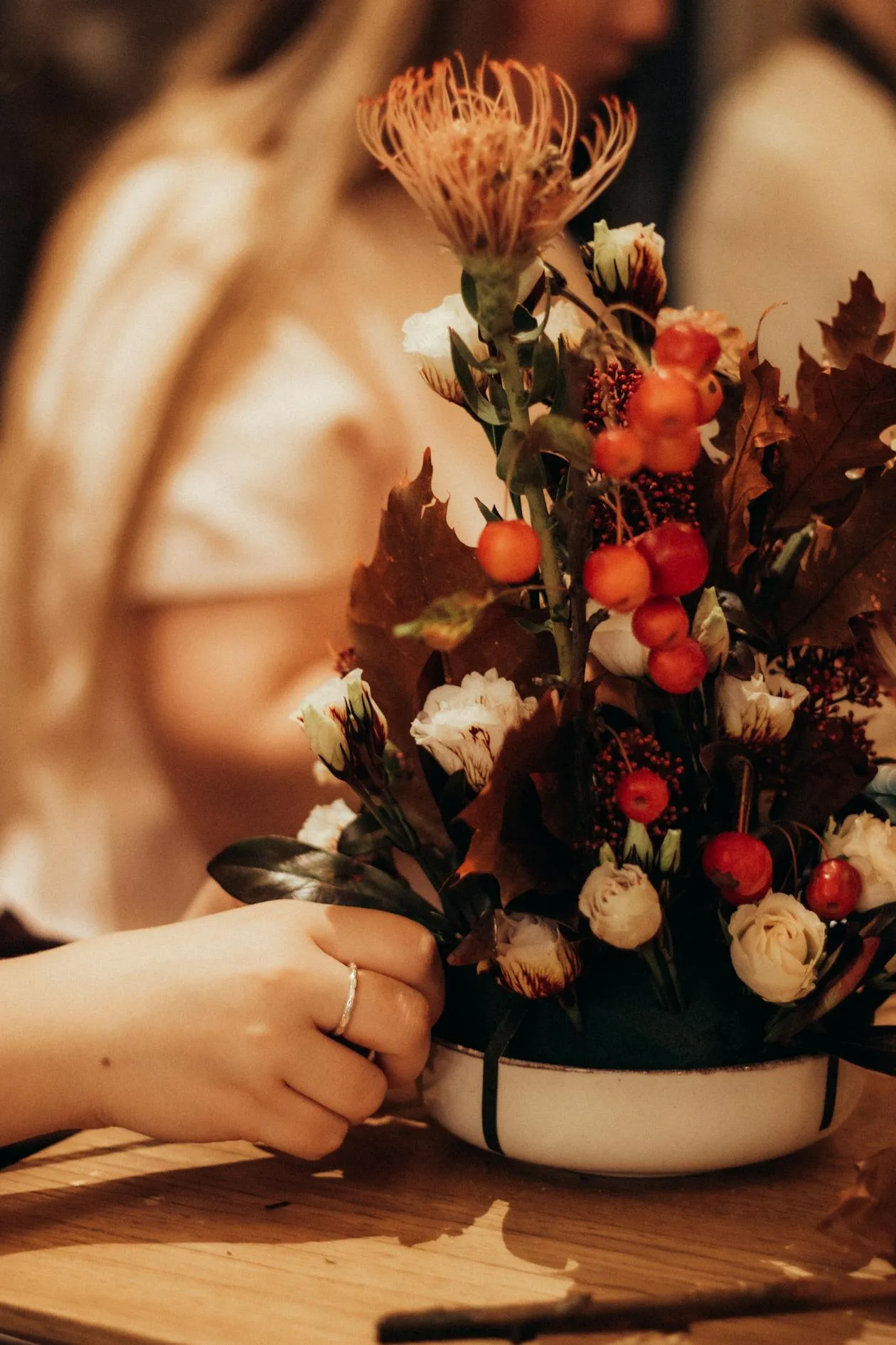 A cosy autumn floral arrangement with warm orange and red tones