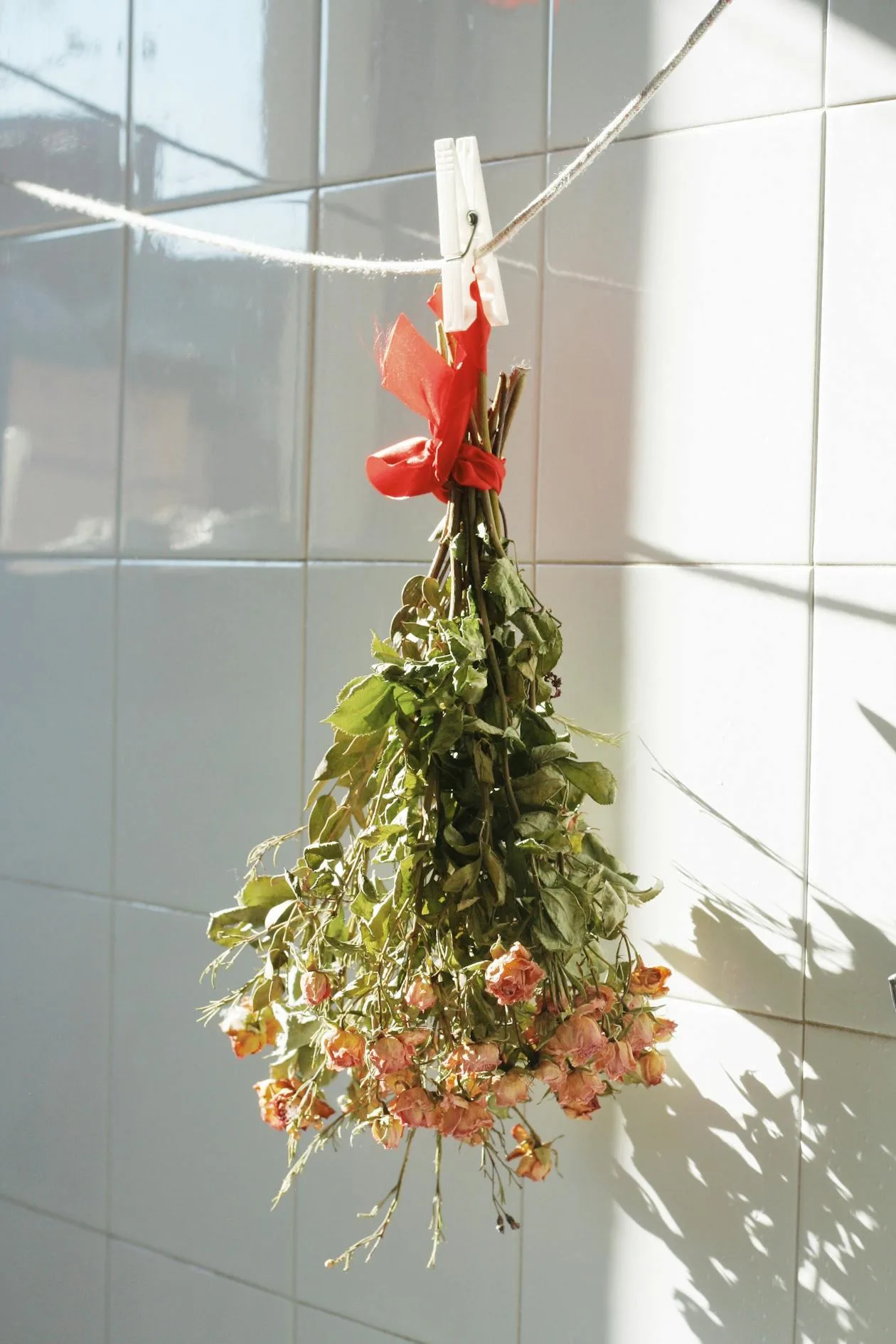 A bouquet of flowers hanging upside down on a clothesline to dry