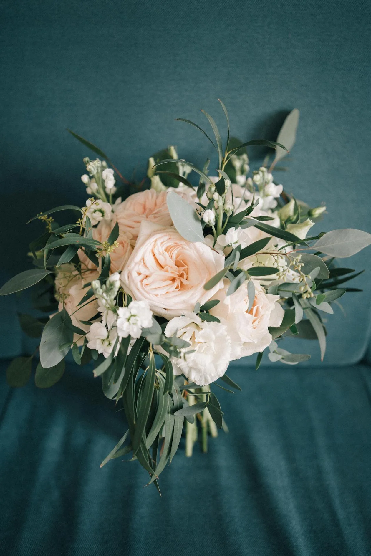 Close-up of an elegant bridal bouquet with peach roses and greenery