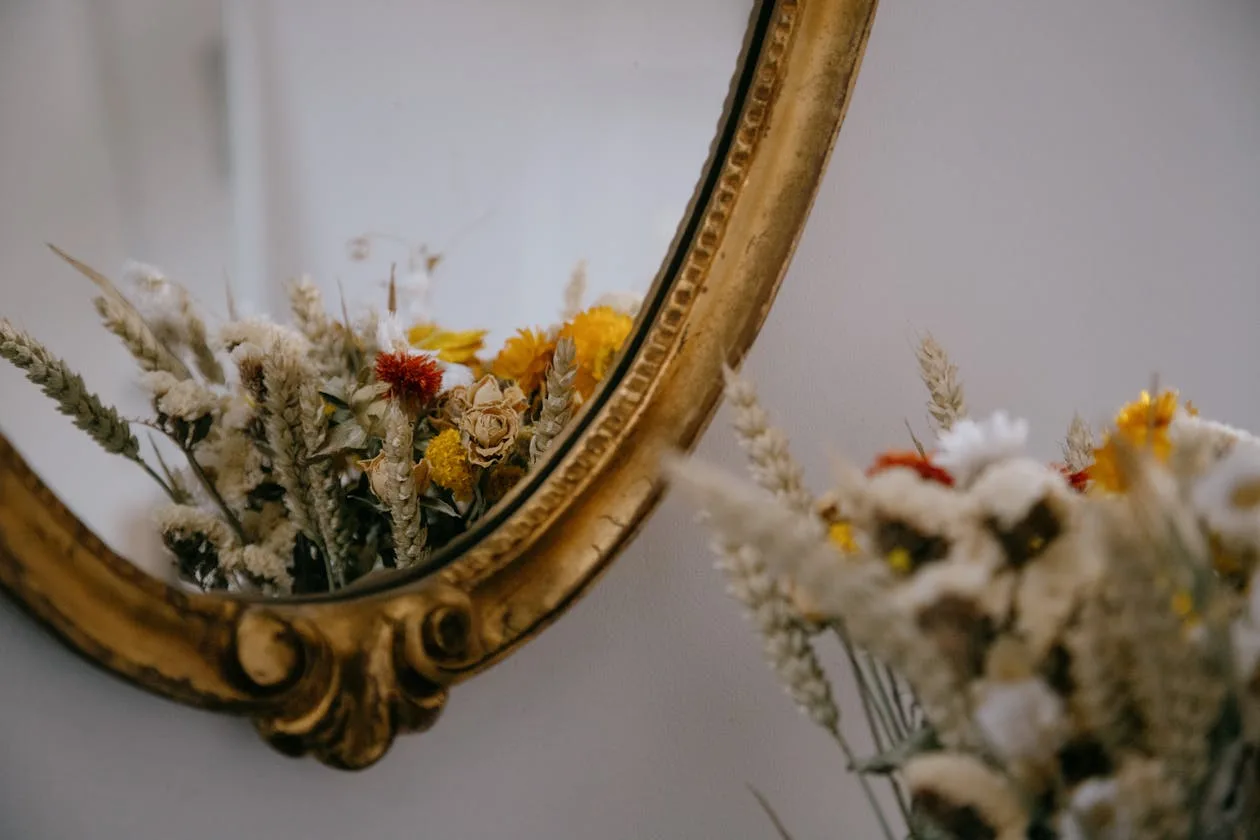 Bouquet of soft gentle flowers placed against a mirror
